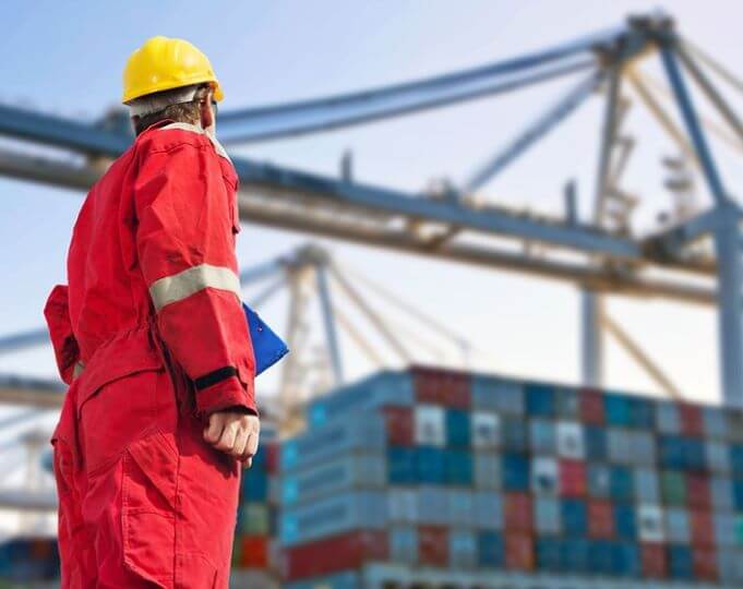 Worker with hard hat looking at freight containers