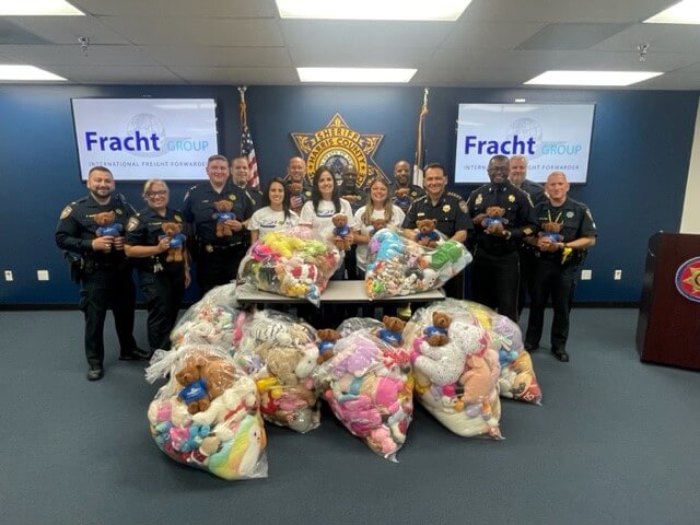 Fracht employees and police officers with toys in bags