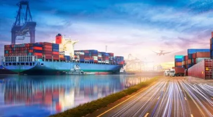 Large ocean vessel carrying freight next to road