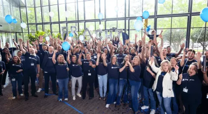 Fracht Group North America employees celebrating Top Workplaces award with confetti, balloons, and raised hands in a bright office space.