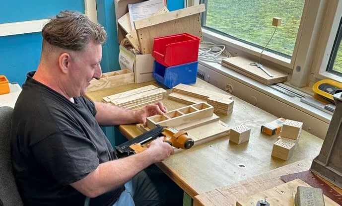 Fracht employee building an insect hotel