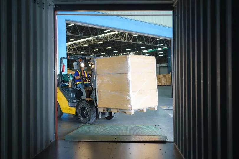 Machine lifting a crate with cargo on it