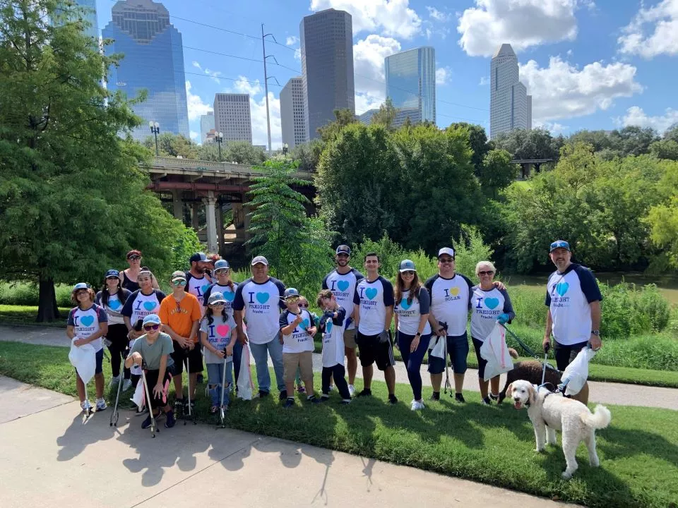 Fracht employees and family cleaning up a park