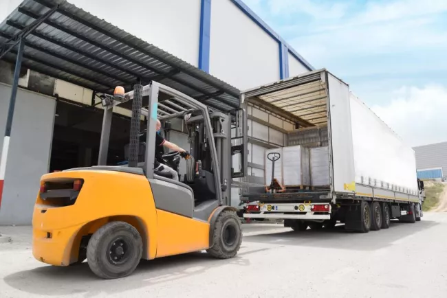 Machine lifting cargo into a truck