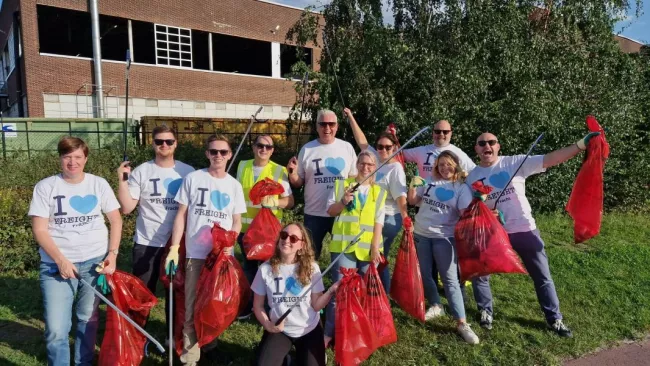 Fracht employees outside cleaning up a park