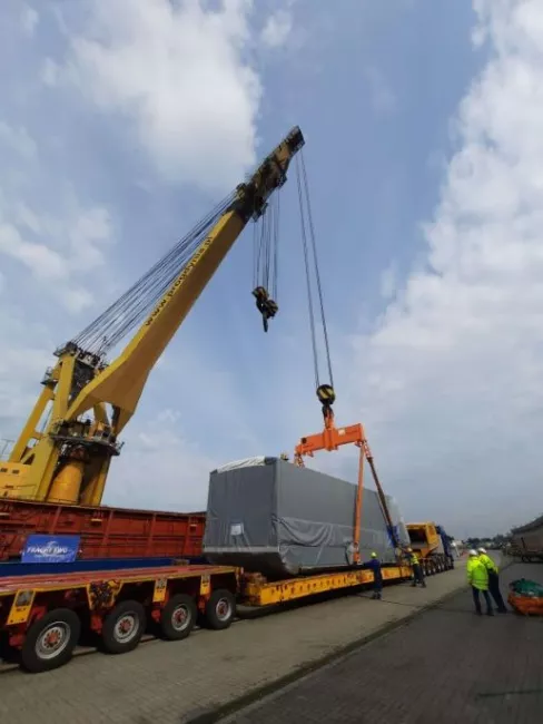 Crane lifting cargo onto flatbed truck